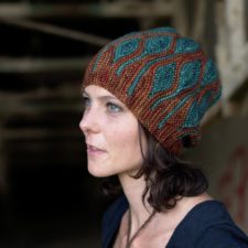 Two-color sideways knit hat with short-row leaf motifs throughout.