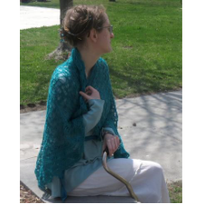 Sarah is wrapped in a large, lacy shawl, a mobility aid at her side.