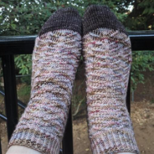 Socks combine lace elements with a traveling cable.