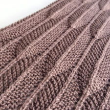 Shawl with textured pattern that resembles feathers.