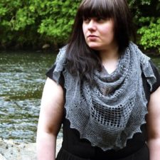 Model stands by stream with lacy shawl cascading down her shirt.