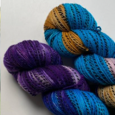 Zebra yarn in the colors of Advent church candles, cool purple and aqua and warm gold.
