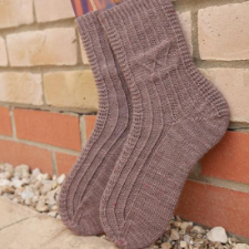 Socks with subtle texture of vertical stripes and downward pointing arrows.