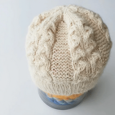 Cabled beanie with two side by side cables, alternating with wide garter stitch sections.