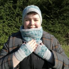 Matching colorwork beanie, cowl and mitts. Pattern is groups of rounded leaves.