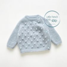 Long-sleeve baby sweater that buttons down one side. Front has bobbles.