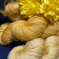 Soft yellow tonal yarn on variety of bases with a silk chrysanthemum.