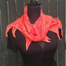 Small shawl with points resembing tongues of flame, shown in a red-hot color.