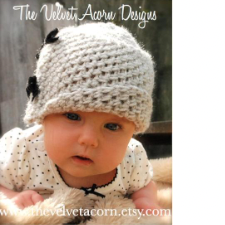 Baby wearing crocheted cloche hat with bows down one side.
