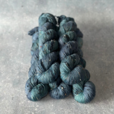 Tweed variegated yarn in deep blue and blue green.