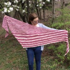 Shallow triangular shawl in two colors with wide stripes at the bottom and narrow stripes at the top.