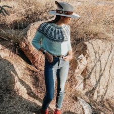 Long-sleeve pullover with Navajo geometric patterned yoke. Jennifer models it outdoors, looking across a desert landscape.
