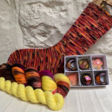 Variegated sock and yarns used, along with small box of chocolates.