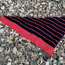 Striped triangular shawl with lacy band down one of the lower sides.