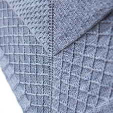 Triangular shawl with basketweave and lattice textures.