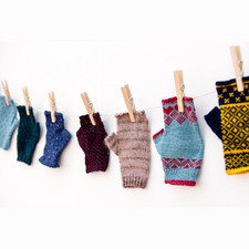 Clothesline of fingerless mitts in different colorwork patterns.