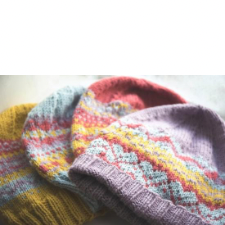 Four colorwork beanie patterns in a number of colors, with modified traditional motifs.