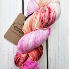 Variegated and speckled yarn in berries and cream with a hint of apricot.