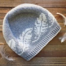 Beanie in two colors with large feather motif.