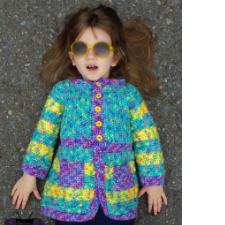 Little girl in sunglasses lies on the ground in a colorful cardigan with contrasting edges and pockets and long striped sleeves.