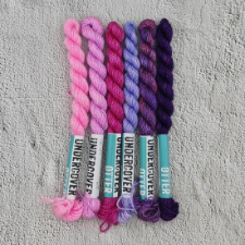 Six skeins of embroidery-weight yarn in pinks, purples and fuschia.