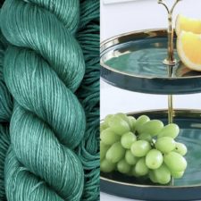 Skein of green and a fruit plate made of malachite with grapes on it.