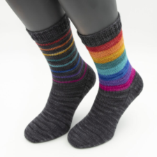 Dark socks with rainbow stripes, narrow on one sock, wider on the other.