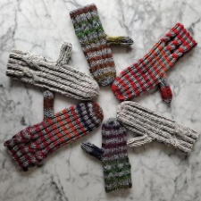 Six striped and solid mittens with simple cable just before the cuff.
