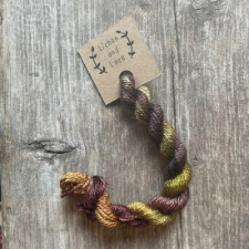 Twisted hank of embroidery-weight wool in earthy brown, green and gray.