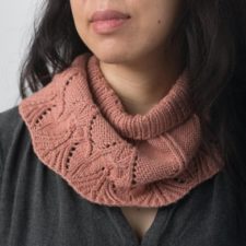 Natsuyo is a lightweight cowl inspired by the early spring, when shoots begin to dot the ground. A leaf motif encircles the bottom hem, and the parallel lines of twisted knit stitches call to mind a trellis awaiting new growth.