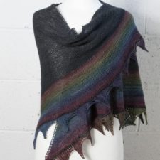 Laceweight triangular shawl, dark with dim rainbow at the lower edge.