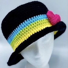 Dark bucket hat with stripes above brim. Crocheted heart is attached to bright stripes.