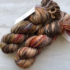 Coffee colors in variegated yarn with a touch of bright red.