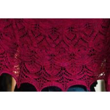 Deep red semicircular lace shawl in DK or Worsted. Bottom edge is blocked into points.