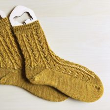 Textured socks with thistle flower-style stitch motif.