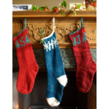 Mainly solid color stockings with tree motifs and initial at the cuff.