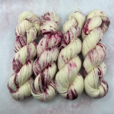 Speckled yarn that resembles vanilla ice cream with blackberries.