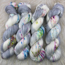 Variegated yarn in cream with bright speckles, and cool gray.
