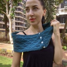 Buttoned cowl with textured diamond pattern, worn off the shoulder.