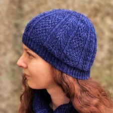 Textured hat divided into vertical sections between moss stitch and a leafy pattern.