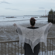 Shawl takes the form of half of a snowflake. hem comes to 5 points, with a large snowflake pattern across the main body of the shawl.