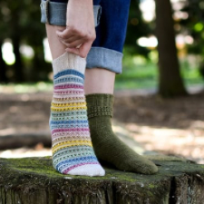 Two sock patterns. One has stripes divided by yarnovers every few rows. The other is solid with just a few rows of yarnovers near the top.