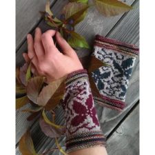 Colorwork wristlets about five inches long with leaf patterns and multicolor garter stitch cuffs at each end.