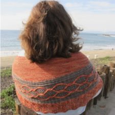 Crescent shawl in two colors with contrasting cables.