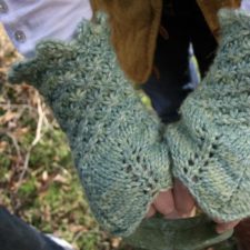 Fingerless mitts with textured wrists and eyelet-decorated hands.