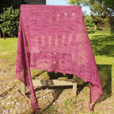 Large triangular shawl with wide lace border at the bottom.