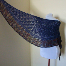 Lace crescent shawl with ribbing that looks like large feathers in a complementary colorway.