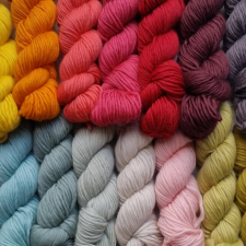 A dozen skeins of yarn in bright and pastel colors.