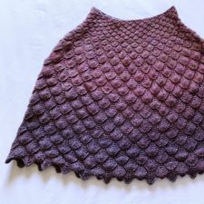 Short poncho knit in scales.