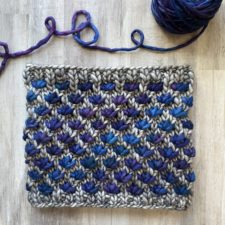 Two-color cowl with lotus shaped stitches.